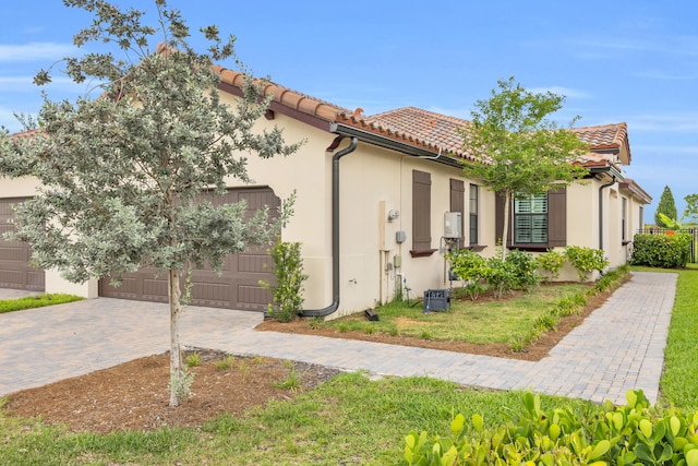 1246 Tangled Orchard Trce, Loxahatchee, FL 33470 - mediterranean / spanish house featuring a garage, decorative driveway, a tiled roof, and stucco siding