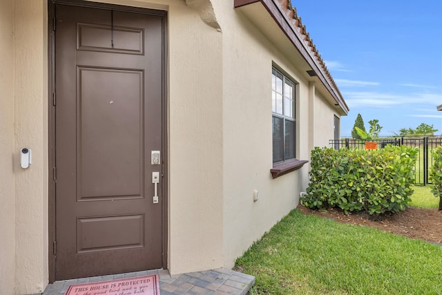 1246 Tangled Orchard Trce, Loxahatchee, FL 33470 - view of exterior entry featuring stucco siding and a tile roof