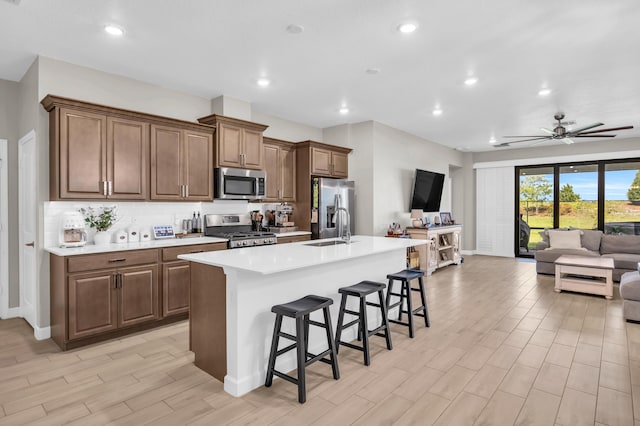 1246 Tangled Orchard Trce, Loxahatchee, FL 33470 - kitchen with appliances with stainless steel finishes, open floor plan, a sink, an island with sink, and a breakfast bar area