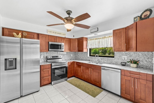 4260 Mango Tree Ct Unit B, Boynton Beach, FL 33436 - kitchen featuring stainless steel appliances, a sink, decorative backsplash, a ceiling fan, and brown cabinetry