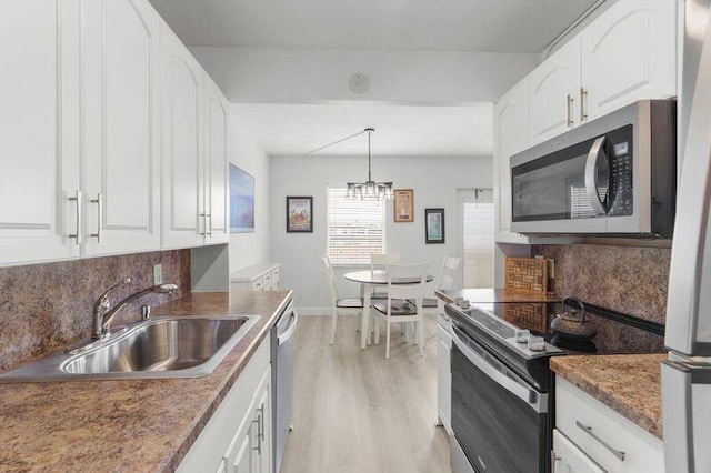4051 Guildford C Unit 4051, Boca Raton, FL 33434 - kitchen with appliances with stainless steel finishes, a sink, white cabinets, light wood-style flooring, and tasteful backsplash
