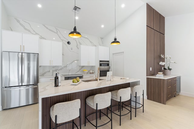 3099 NW 25th Way, Boca Raton, FL 33434 - kitchen with appliances with stainless steel finishes, modern cabinets, high vaulted ceiling, white cabinetry, and a kitchen breakfast bar