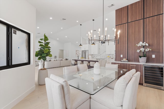 3099 NW 25th Way, Boca Raton, FL 33434 - dining area featuring wine cooler, light wood-type flooring, a chandelier, vaulted ceiling, and recessed lighting