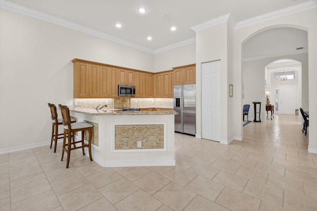 7030 Boscanni Dr Unit 7030, Boynton Beach, FL 33437 - kitchen featuring appliances with stainless steel finishes, arched walkways, light tile patterned floors, a peninsula, and backsplash