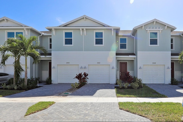 242 SE Woodbark St, Port Saint Lucie, FL 34984 - townhome / multi-family property with a garage, stucco siding, and driveway