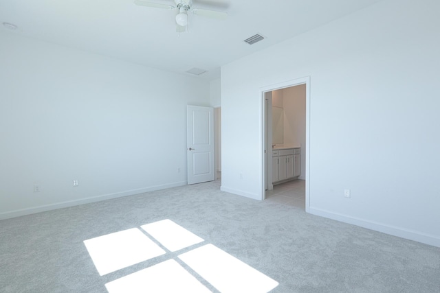 242 SE Woodbark St, Port Saint Lucie, FL 34984 - unfurnished bedroom featuring light colored carpet, baseboards, ensuite bathroom, and a ceiling fan