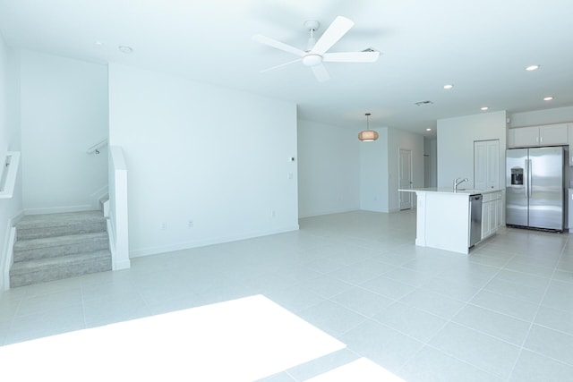242 SE Woodbark St, Port Saint Lucie, FL 34984 - unfurnished living room with recessed lighting, a ceiling fan, stairs, a sink, and light tile patterned floors