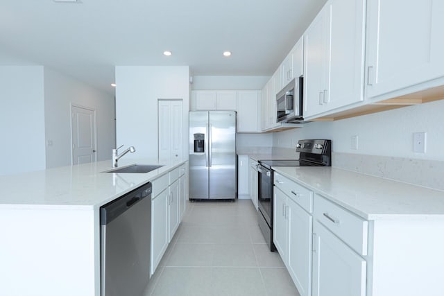 242 SE Woodbark St, Port Saint Lucie, FL 34984 - kitchen featuring stainless steel appliances, a sink, a kitchen island with sink, white cabinetry, and light tile patterned flooring