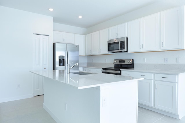 242 SE Woodbark St, Port Saint Lucie, FL 34984 - kitchen featuring stainless steel appliances, a sink, white cabinets, an island with sink, and recessed lighting