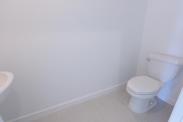 242 SE Woodbark St, Port Saint Lucie, FL 34984 - bathroom featuring baseboards, toilet, and tile patterned flooring