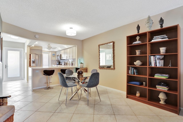 2731 NE 14th Cswy Unit 702, Pompano Beach, FL 33062 - dining room featuring a textured ceiling, light tile patterned flooring, baseboards, and a ceiling fan