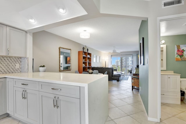 2731 NE 14th Cswy Unit 702, Pompano Beach, FL 33062 - kitchen with a peninsula, light countertops, backsplash, and light tile patterned floors