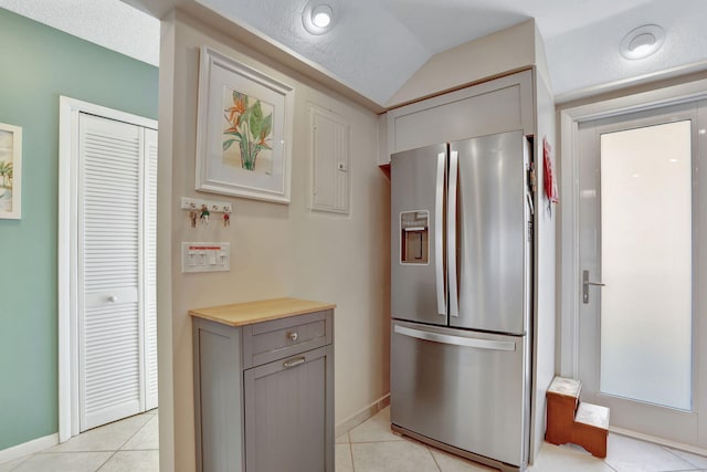 2731 NE 14th Cswy Unit 702, Pompano Beach, FL 33062 - kitchen with stainless steel fridge, gray cabinetry, baseboards, light tile patterned flooring, and vaulted ceiling
