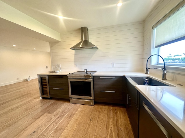 3 Colonial Club Dr Unit 104, Boynton Beach, FL 33435 - kitchen featuring wall chimney range hood, electric range, light wood-type flooring, wine cooler, and light countertops