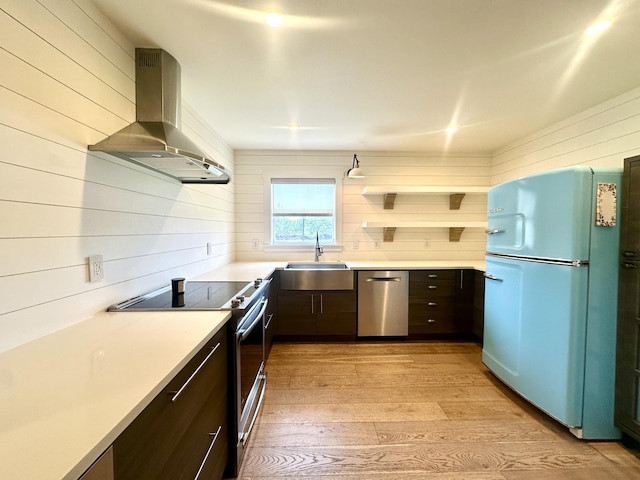 3 Colonial Club Dr Unit 104, Boynton Beach, FL 33435 - kitchen featuring appliances with stainless steel finishes, island exhaust hood, a sink, wood walls, and light wood finished floors