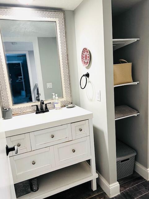 1714 17th Ct, Jupiter, FL 33477 - bathroom featuring vanity, wood finished floors, and baseboards