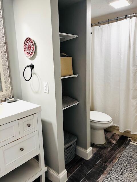 1714 17th Ct, Jupiter, FL 33477 - bathroom with wood finished floors, toilet, vanity, and a shower with shower curtain
