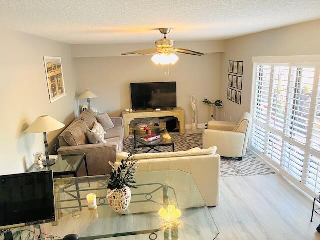 1714 17th Ct, Jupiter, FL 33477 - living area with a textured ceiling, wood finished floors, and a ceiling fan