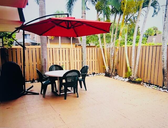1714 17th Ct, Jupiter, FL 33477 - fenced backyard with outdoor dining area and a patio