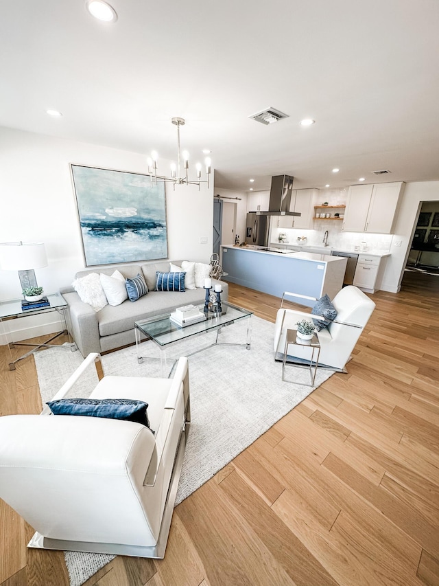 1188 W Camino Real, Boca Raton, FL 33486 - living room featuring a chandelier, recessed lighting, and light wood-style flooring