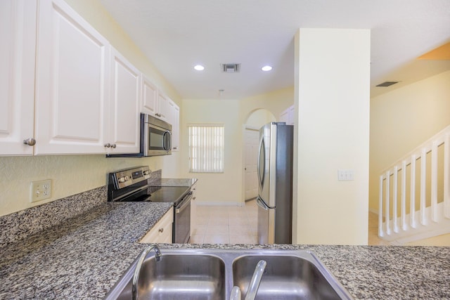 5441 Via Delray Unit 17, Delray Beach, FL 33484 - kitchen with appliances with stainless steel finishes, light tile patterned floors, white cabinets, recessed lighting, and baseboards