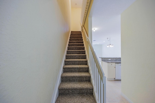 5441 Via Delray Unit 17, Delray Beach, FL 33484 - stairs with tile patterned flooring, a chandelier, a textured wall, and baseboards