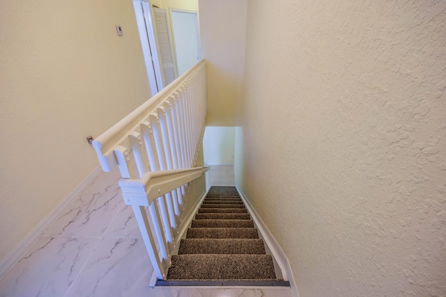 5441 Via Delray Unit 17, Delray Beach, FL 33484 - stairway featuring marble finish floors, a textured wall, and baseboards