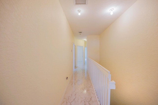 5441 Via Delray Unit 17, Delray Beach, FL 33484 - hallway with light marble finish flooring, an upstairs landing, a textured wall, and baseboards