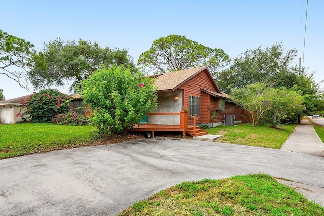 4744 Dolphin Dr, Lake Worth, FL 33463 - view of front of property with a front yard, central AC, and a deck