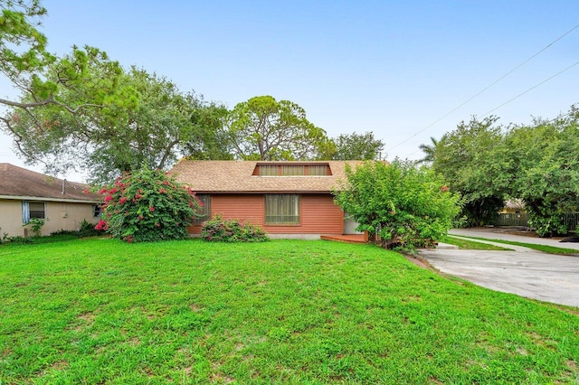 4744 Dolphin Dr, Lake Worth, FL 33463 - view of front of house featuring a front lawn, a shingled roof, and driveway