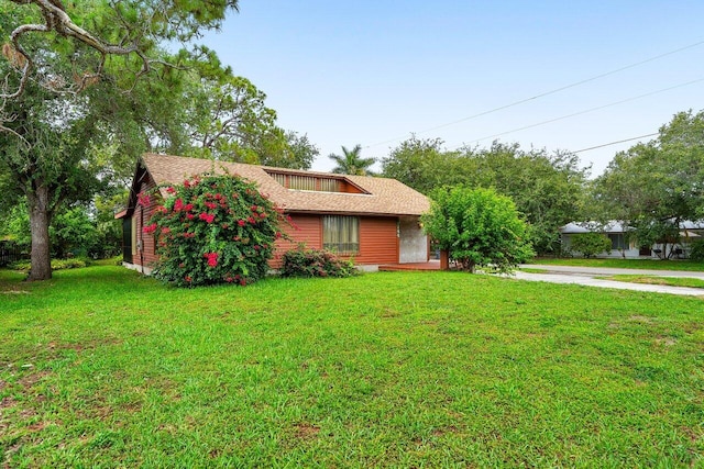 4744 Dolphin Dr, Lake Worth, FL 33463 - view of front of home with a front lawn and a shingled roof