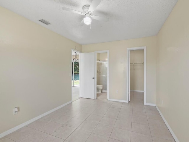 526 NW Kingston St, Port Saint Lucie, FL 34983 - unfurnished bedroom featuring a spacious closet, a textured ceiling, light tile patterned flooring, a closet, and baseboards