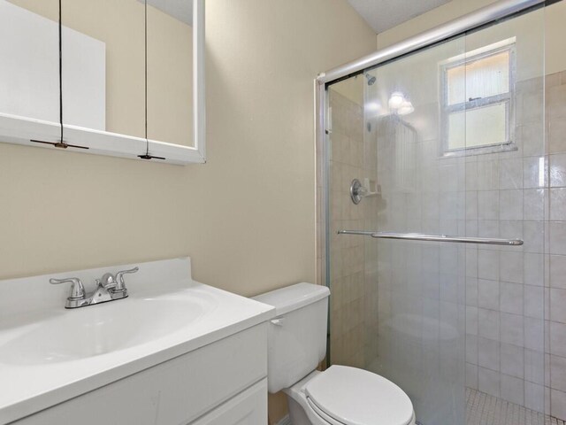 526 NW Kingston St, Port Saint Lucie, FL 34983 - bathroom featuring toilet, a stall shower, and vanity