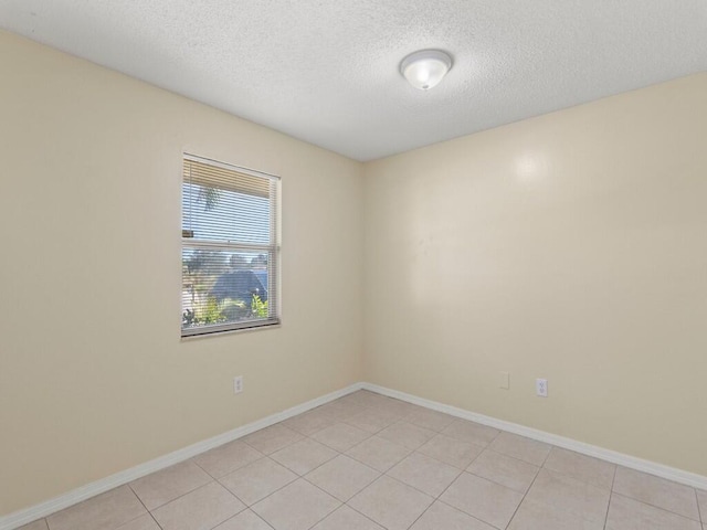 526 NW Kingston St, Port Saint Lucie, FL 34983 - spare room with a textured ceiling, baseboards, and light tile patterned flooring