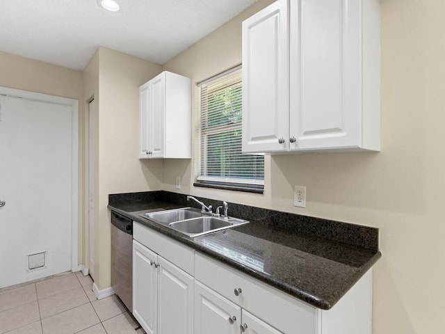 526 NW Kingston St, Port Saint Lucie, FL 34983 - kitchen with a sink, stainless steel dishwasher, dark countertops, white cabinets, and baseboards
