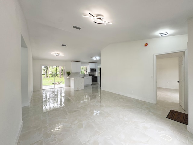 15809 85th Rd N, The Acreage, FL 33470 - unfurnished living room with light marble finish floors, vaulted ceiling, and baseboards