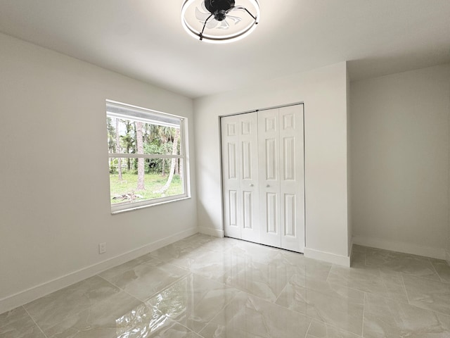 15809 85th Rd N, The Acreage, FL 33470 - unfurnished bedroom with light marble finish floors, baseboards, and a closet