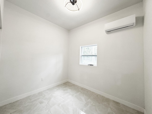 15809 85th Rd N, The Acreage, FL 33470 - empty room with a wall mounted AC, baseboards, and light marble finish flooring