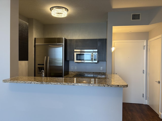 550 Okeechobee Blvd Unit 825, West Palm Beach, FL 33401 - kitchen with stainless steel appliances, dark wood finished floors, stone counters, and a peninsula