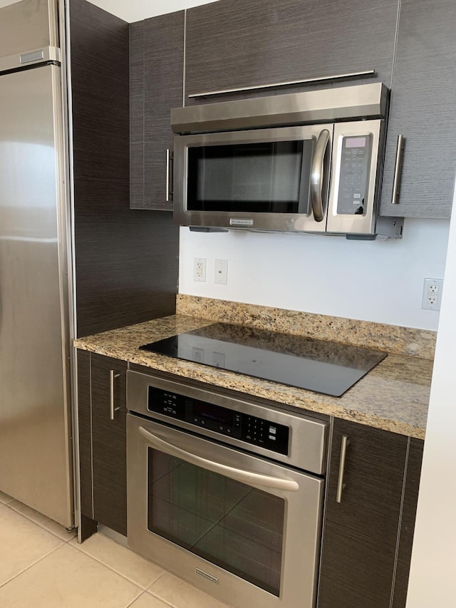 550 Okeechobee Blvd Unit 825, West Palm Beach, FL 33401 - kitchen with appliances with stainless steel finishes, light tile patterned flooring, dark brown cabinets, and modern cabinets