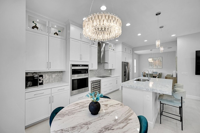 5452 Macoon Way, Westlake, FL 33470 - kitchen with a chandelier, stainless steel appliances, wall chimney exhaust hood, a sink, and beverage cooler