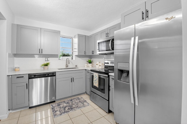 9370 SW 8th St Unit 410, Boca Raton, FL 33428 - kitchen with appliances with stainless steel finishes, gray cabinetry, a sink, light countertops, and a textured ceiling
