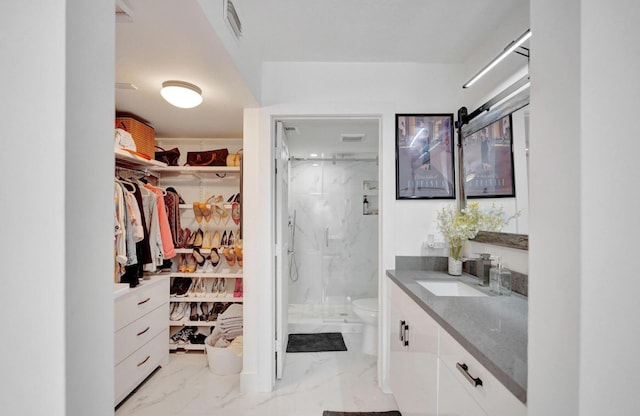 2768 Carambola Cir S Unit 301, Coconut Creek, FL 33066 - bathroom featuring marble look tile flooring, a marble finish shower, vanity, toilet, and a walk in closet