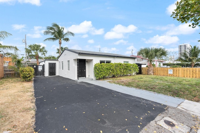 617 54th St, West Palm Beach, FL 33407 - view of front of property featuring stucco siding, driveway, and a gate
