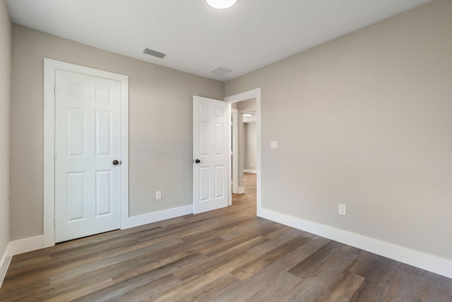 617 54th St, West Palm Beach, FL 33407 - unfurnished bedroom with wood finished floors and baseboards