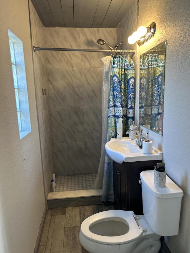 617 54th St, West Palm Beach, FL 33407 - full bathroom featuring toilet, wood-type flooring, a shower stall, a textured wall, and vanity