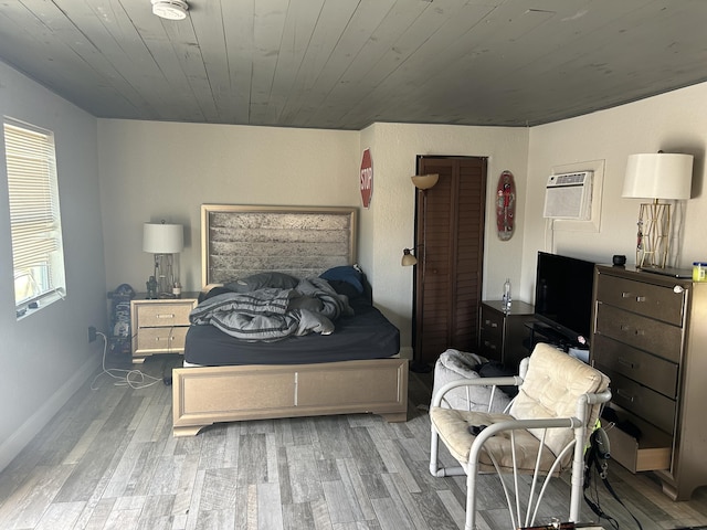 617 54th St, West Palm Beach, FL 33407 - bedroom with wood finished floors, wooden ceiling, a wall unit AC, and baseboards