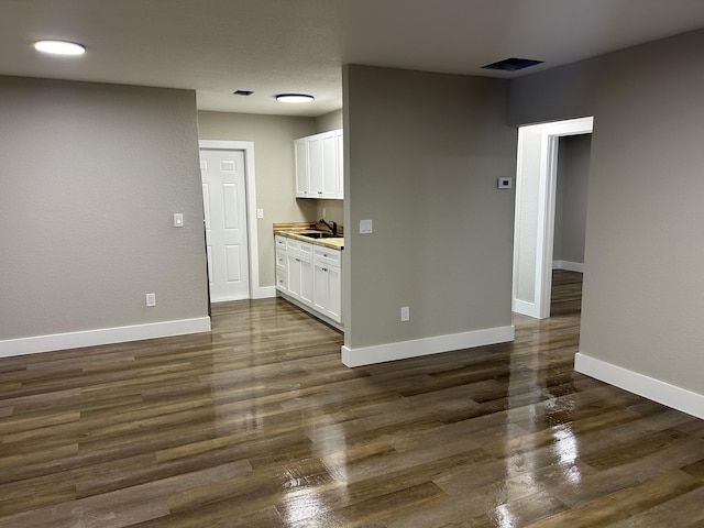617 54th St, West Palm Beach, FL 33407 - empty room featuring a sink, baseboards, and dark wood-style floors