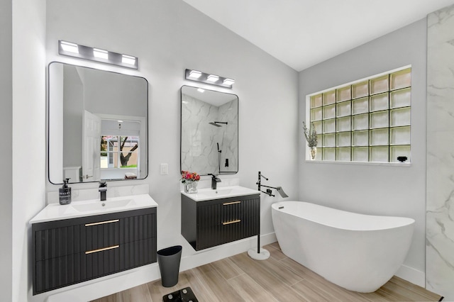 9640 Cherry Blossom Ct, Boynton Beach, FL 33437 - full bathroom featuring a freestanding bath, a marble finish shower, wood finished floors, two vanities, and vaulted ceiling