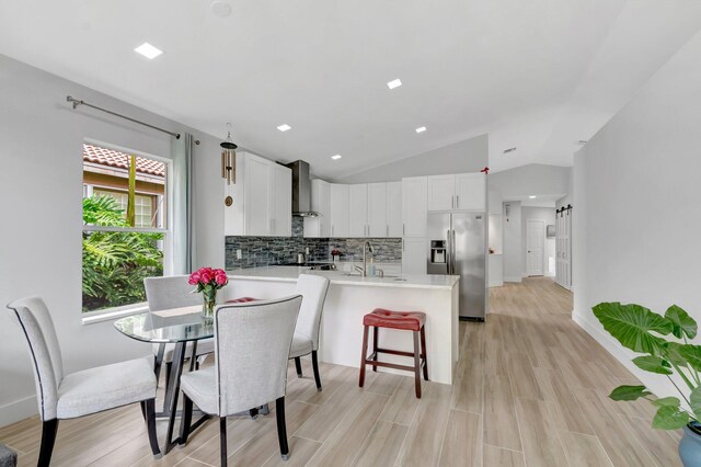 9640 Cherry Blossom Ct, Boynton Beach, FL 33437 - dining area featuring vaulted ceiling, light wood-type flooring, and baseboards
